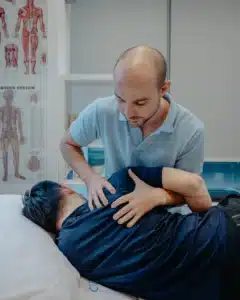 Physiotherapist performing manual spinal therapy to complement guided physiotherapy exercises for lower back pain.