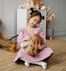 Asian girl playing with toy doll