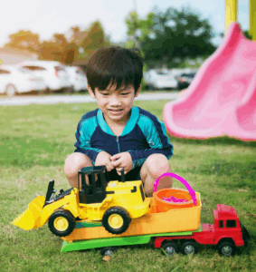 Asian boy playing with a toy car