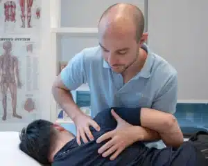 Physiotherapist providing manual treatment to maximise the benefits of shockwave therapy for shoulder pain.