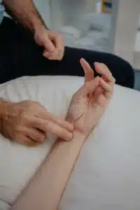A physiotherapist checking a patient’s wrist during an assessment.