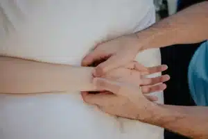 Physiotherapist assessing a patient’s wrist during a clinical examination.