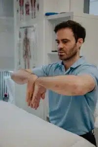 Demonstration of a gentle wrist stretch with the palms together.